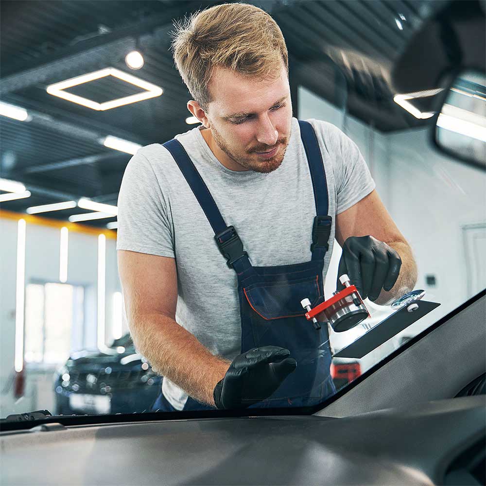 Autoglaser, der in Heinsberg bei Aachen eine Windschutzscheibe repariert